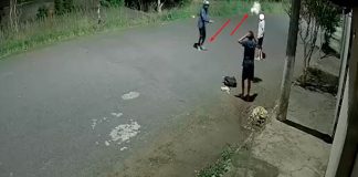 Revolta na fuga: bandido desconta raiva em flores após tentativa de roubo frustrada Captura de tela de câmera de segurança mostrando um assaltante de capacete chutando um buquê de flores no chão enquanto vítimas se afastam