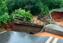 Rompimento de bueiro abre cratera gigante e fecha pista da MGC-251 Trecho da rodovia MGC-251 em Dom Bosco totalmente bloqueado com cones e galhos devido a uma grande cratera aberta no asfalto