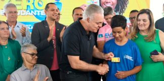 Atenção estudantes: prazo para renovar o Tarifa Zero abre hoje para 52 mil beneficiários Estudante segurando um celular com o aplicativo Ubetrans aberto em frente a um ônibus do transporte público de Uberlândia