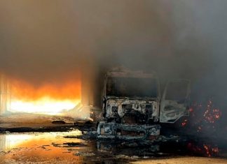 Galpão de palha de milho fica completamente destruído após incêndio em Patos de Minas Fumaça densa e chamas altas consumindo a estrutura metálica de um galpão agrícola em uma área rural