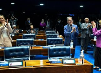 Senado aprova ampliação da licença-paternidade: veja o que muda para os pais Pai segurando um bebê recém-nascido no colo, simbolizando o novo período de licença-paternidade aprovado pelo Senado
