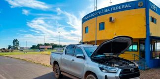 Homem paga R$ 223 mil em Hilux e acaba na delegacia por adulteração na BR-050 Policial Rodoviário Federal inspecionando caminhonete Toyota Hilux prata parada no acostamento da BR-050