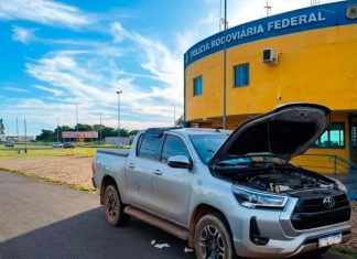 Homem paga R$ 223 mil em Hilux e acaba na delegacia por adulteração na BR-050 Policial Rodoviário Federal inspecionando caminhonete Toyota Hilux prata parada no acostamento da BR-050