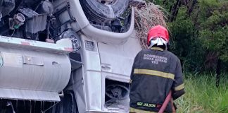 Caminhão com combustível capota na BR-153 e mobiliza equipes contra vazamento na Prata Caminhão de combustível capotado no canteiro lateral da rodovia BR-153, com equipes de bombeiros aplicando espuma de resfriamento.