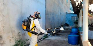 Araguari recebe reforço estadual após casos de dengue subirem 338% Agente de endemias aplicando inseticida com equipamento de fumacê em rua de Araguari.