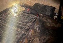 Susto em Araxá: Homem acorda com colchão em chamas após dormir com cigarro aceso Quarto com paredes chamuscadas e restos de colchão queimado após incêndio causado por cigarro