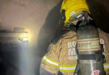 Corpo de Bombeiros é acionado para combater chamas em farmácia na Zona Norte de Uberlândia Fachada de farmácia em Uberlândia com viatura do Corpo de Bombeiros e fumaça ao fundo durante a madrugada.