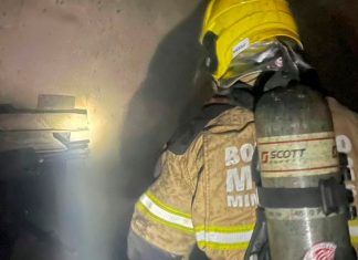 Corpo de Bombeiros é acionado para combater chamas em farmácia na Zona Norte de Uberlândia Fachada de farmácia em Uberlândia com viatura do Corpo de Bombeiros e fumaça ao fundo durante a madrugada.