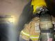 Corpo de Bombeiros é acionado para combater chamas em farmácia na Zona Norte de Uberlândia Fachada de farmácia em Uberlândia com viatura do Corpo de Bombeiros e fumaça ao fundo durante a madrugada.