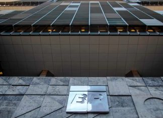 Crise do Diesel: Petrobras teme nova greve de caminhoneiros após impasse no preço Fachada da sede da Petrobras com a bandeira do Brasil ao fundo em um dia ensolarado.