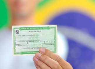 Prazo para tirar o título de eleitor 2026 termina em 6 de maio; veja como fazer Urna eletrônica e cartaz da Justiça Eleitoral indicando as eleições de 2026