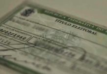 Justiça Eleitoral amplia atendimento em Uberlândia para reta final do cadastro Título de eleitor brasileiro sobre uma mesa, representando a regularização eleitoral