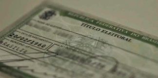 Justiça Eleitoral amplia atendimento em Uberlândia para reta final do cadastro Título de eleitor brasileiro sobre uma mesa, representando a regularização eleitoral