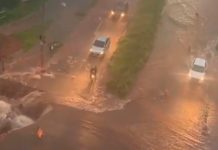 Chuva forte amplia cratera no Jaraguá e causa alagamentos em Uberlândia Vista aérea de grande cratera em asfalto na Avenida Jacarandá, cercada por faixas de isolamento e lama após chuva.