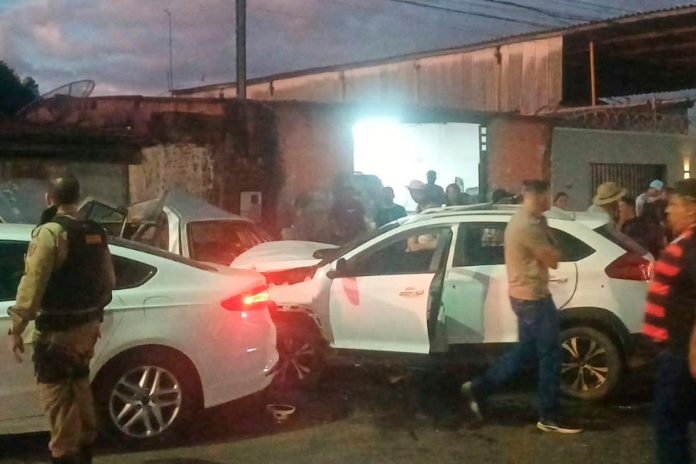 Carro batido após motorista ser baleado em cruzamento de Araguari; isolamento policial no local.