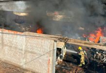 Fogo em calçada invade depósito de peças e causa destruição em Ituiutaba Bombeiros combatendo chamas e fumaça preta em depósito de veículos e peças em Ituiutaba.