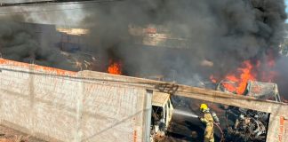 Fogo em calçada invade depósito de peças e causa destruição em Ituiutaba Bombeiros combatendo chamas e fumaça preta em depósito de veículos e peças em Ituiutaba.