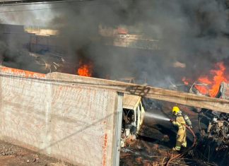 Fogo em calçada invade depósito de peças e causa destruição em Ituiutaba Bombeiros combatendo chamas e fumaça preta em depósito de veículos e peças em Ituiutaba.