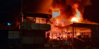 Bombeiros combatem incêndio em ferro-velho de Uberlândia; fogo atingiu casa e carro Bombeiros combatendo chamas altas em um ferro-velho à noite em Uberlândia.