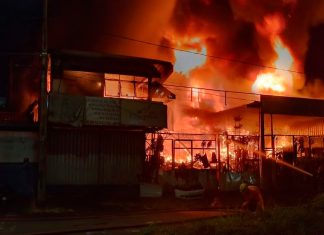Bombeiros combatem incêndio em ferro-velho de Uberlândia; fogo atingiu casa e carro Bombeiros combatendo chamas altas em um ferro-velho à noite em Uberlândia.