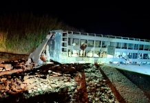 Grave acidente na BR-365: Carreta com 70 bois tomba e desaba guarita em Patos de Minas Ambulância do Samu e viatura dos Bombeiros com luzes acesas à noite durante resgate em acidente na rodovia BR-365.
