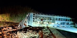 Grave acidente na BR-365: Carreta com 70 bois tomba e desaba guarita em Patos de Minas Ambulância do Samu e viatura dos Bombeiros com luzes acesas à noite durante resgate em acidente na rodovia BR-365.