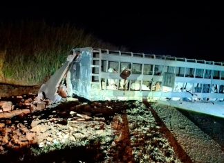 Grave acidente na BR-365: Carreta com 70 bois tomba e desaba guarita em Patos de Minas Ambulância do Samu e viatura dos Bombeiros com luzes acesas à noite durante resgate em acidente na rodovia BR-365.
