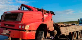 Jovem de 25 anos morre após caminhão carregado de açúcar tombar na BR-146 Caminhão vermelho tombado com as rodas para cima na margem da rodovia BR-146 durante atendimento dos bombeiros.