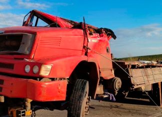 Jovem de 25 anos morre após caminhão carregado de açúcar tombar na BR-146 Caminhão vermelho tombado com as rodas para cima na margem da rodovia BR-146 durante atendimento dos bombeiros.