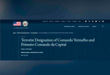 Facções brasileiras PCC e CV entram para a lista de terroristas globais dos EUA Bandeira dos Estados Unidos em primeiro plano com o prédio do Departamento de Estado americano ao fundo em Washington.