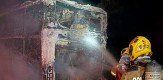Ônibus com 10 ocupantes é destruído por incêndio na BR-050 em Uberlândia Ônibus de viagem consumido por chamas na rodovia BR-050 à noite, com viaturas de emergência ao redor.