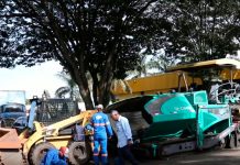 Obras de revitalização começam na Ceasa de Uberlândia com novo asfalto e sinalização Máquinas pavimentadoras aplicando asfalto novo na área interna da Ceasa de Uberlândia, com caminhões de carga ao fundo.