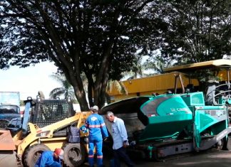 Obras de revitalização começam na Ceasa de Uberlândia com novo asfalto e sinalização Máquinas pavimentadoras aplicando asfalto novo na área interna da Ceasa de Uberlândia, com caminhões de carga ao fundo.