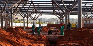 Terminal Sul em Uberlândia: Obras aceleram e atingem quase 40% de execução Vista aérea das obras do Terminal Universitário Sul em Uberlândia, mostrando a montagem das estruturas metálicas e plataformas de ônibus.