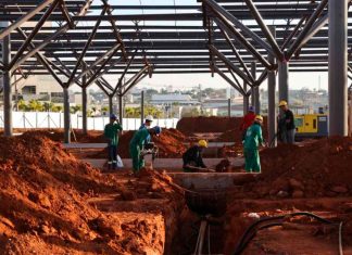 Terminal Sul em Uberlândia: Obras aceleram e atingem quase 40% de execução Vista aérea das obras do Terminal Universitário Sul em Uberlândia, mostrando a montagem das estruturas metálicas e plataformas de ônibus.