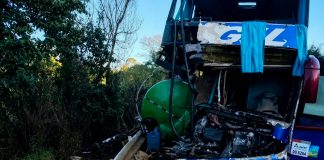 Acidente na MGC-267: tanque de caminhão atinge ônibus e causa duas mortes Ônibus acidentado na rodovia MGC-267 com equipes de resgate no local.