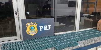 PRF intercepta caminhão com 600 kg de pólvora ilegal em Minas Gerais Agentes da PRF ao lado de caixas de pólvora apreendidas no baú de um caminhão.