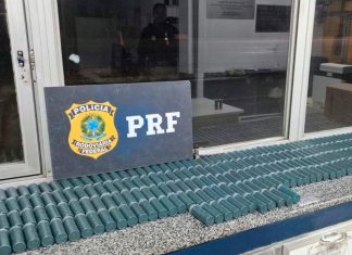 PRF intercepta caminhão com 600 kg de pólvora ilegal em Minas Gerais Agentes da PRF ao lado de caixas de pólvora apreendidas no baú de um caminhão.