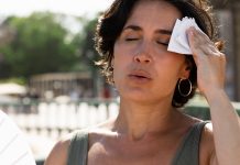 Fim de semana em Uberlândia terá calor de até 37°C e tempo seco Homem se protegendo do sol forte em Uberlândia com termômetros marcando alta temperatura.