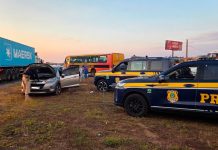 Motorista de 69 anos é preso e carro clonado é apreendido na BR-365 em Uberlândia Viatura da Polícia Rodoviária Federal parada em rodovia com veículo apreendido ao fundo.