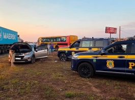 Motorista de 69 anos é preso e carro clonado é apreendido na BR-365 em Uberlândia Viatura da Polícia Rodoviária Federal parada em rodovia com veículo apreendido ao fundo.