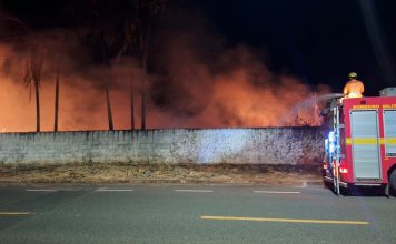 Fumaça e pânico: Série de incêndios em terrenos baldios mobiliza bombeiros em Araguari Bombeiros combatendo incêndio de grande proporção em terreno baldio com fumaça densa em Araguari.