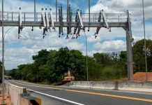 ANTT autoriza reajuste e tarifas da BR-262 sob gestão da Way-262 sofrem aumento Cabine de praça de pedágio em rodovia asfaltada com veículos passando.