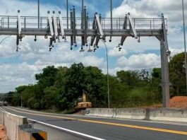 ANTT autoriza reajuste e tarifas da BR-262 sob gestão da Way-262 sofrem aumento Cabine de praça de pedágio em rodovia asfaltada com veículos passando.