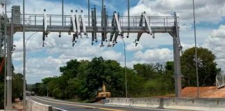 ANTT autoriza reajuste e tarifas da BR-262 sob gestão da Way-262 sofrem aumento Cabine de praça de pedágio em rodovia asfaltada com veículos passando.